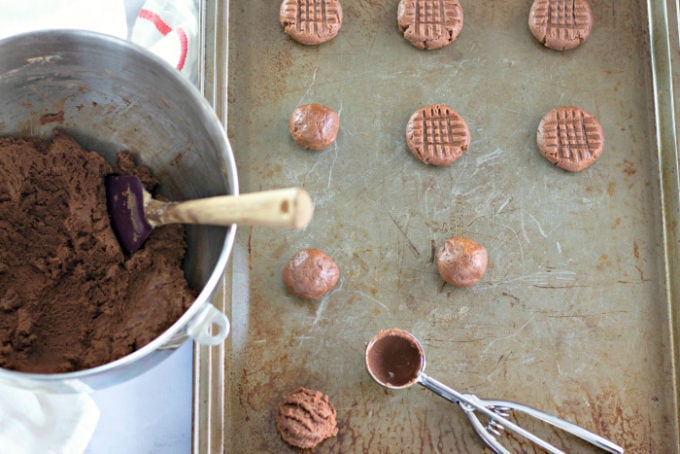 Shaping Chocolate Peanut Butter Cookies on a rustic cookie sheet using a Pampered Chef cookie scoop