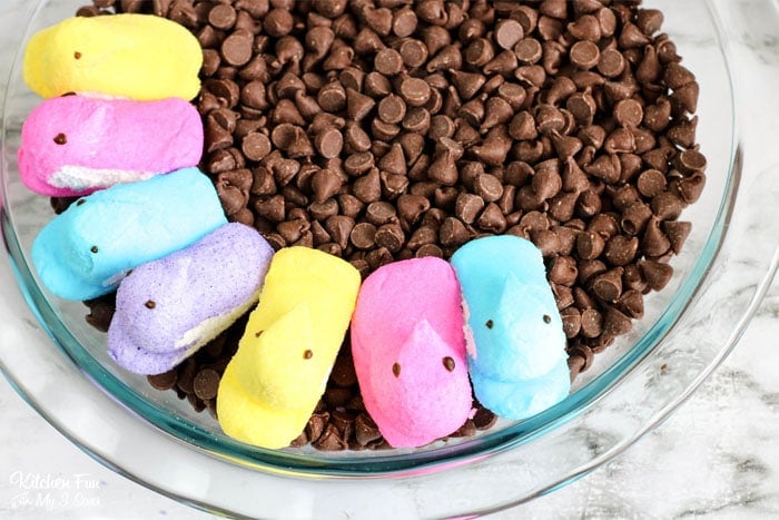 Peeps marshmallows added to a baking dish filled with chocolate chips.