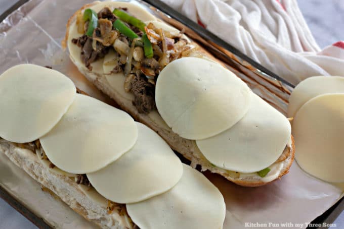 Covering Philly Cheesesteak Cheese Bread with deli-style provolone cheese slices