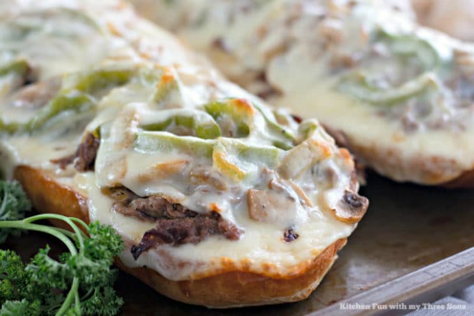 Philly Cheesesteak Cheese Bread on a rustic baking sheet with parsley