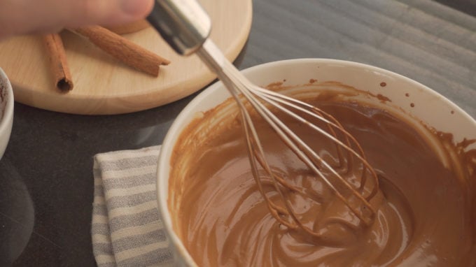 A whisk and a bowl, combining instant coffee, sugar and water