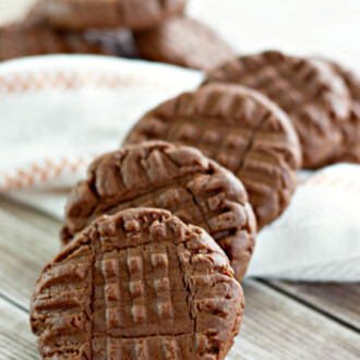 A row of chocolate peanut butter cookies set over a white napkin.