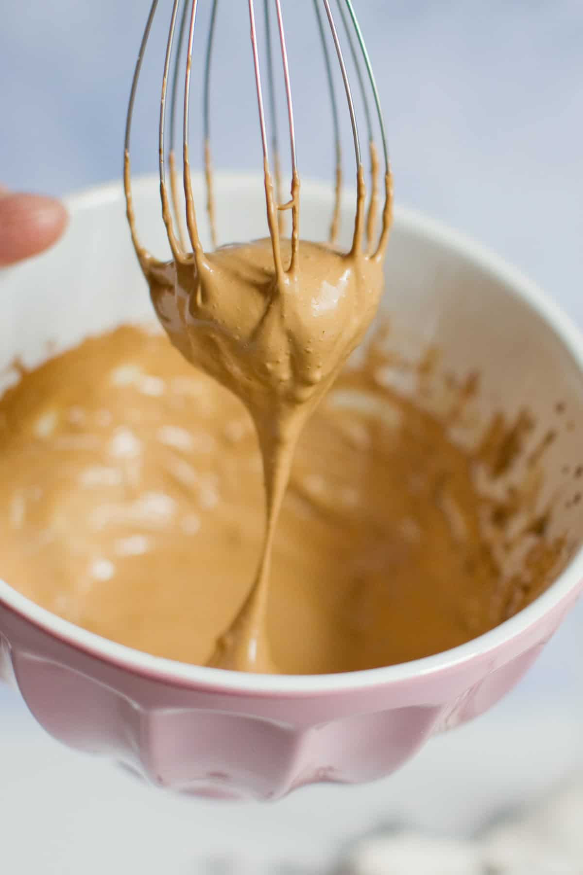 Dalgona coffee, also called "whipped coffee," is known for its light and airy top layer that resembles a coffee flavored fluffy whipped cream. whisking Dalgona Whipped Coffee