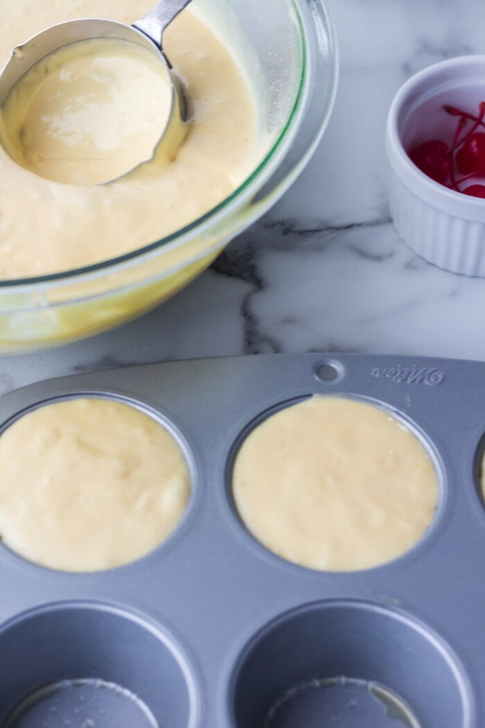 filling muffin cups with batter