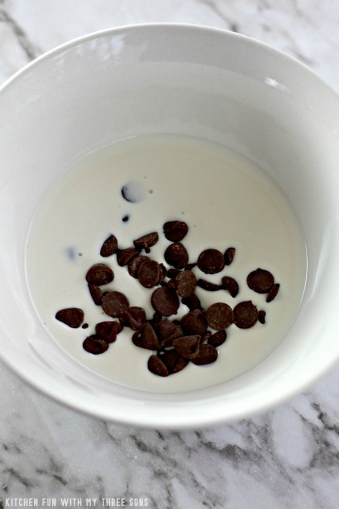 heavy whipping cream and semi-sweet chocolate chips in a white bowl