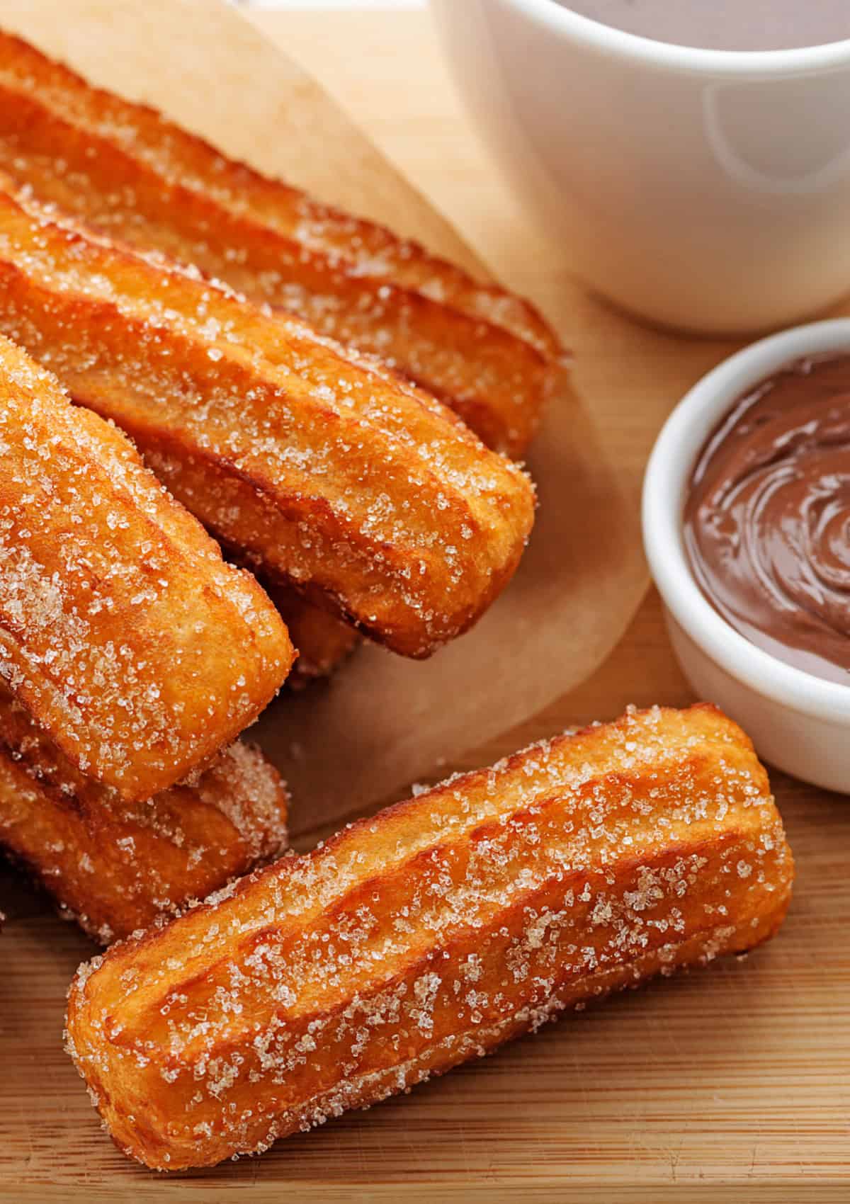 Close up of churros with a dipping sauce next to it