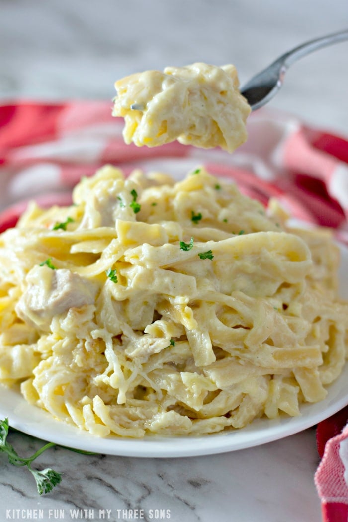 A forkful of creamy Chicken Tetrazzini is lifted over a plate.