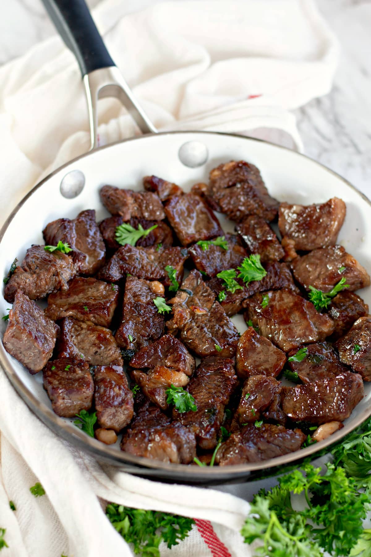 Garlic butter steak bites in a pan with parsley