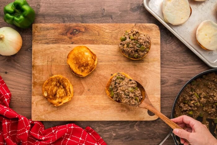 Philly Cheesesteak Sloppy Joes transform the cheesy goodness of a classic cheesesteak into a quick and easy sloppy joe in just 30 minutes. Spooning Philly cheesesteak sloppy joe filling onto buns
