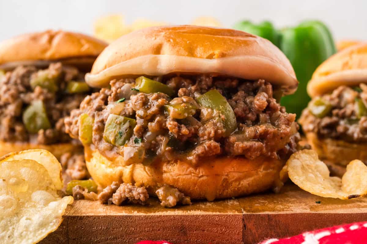 Philly Cheesesteak Sloppy Joes transform the cheesy goodness of a classic cheesesteak into a quick and easy sloppy joe in just 30 minutes. Front view of Philly cheesesteak sloppy joes on a wooden cutting board