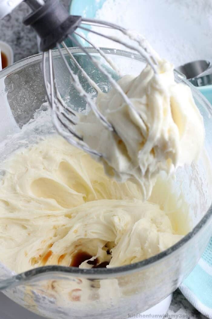 Thick and creamy with a delightfully tangy flavor, this Cream Cheese Frosting recipe requires just 4 basic ingredients and 15 minutes. whisking cream cheese frosting in a standing mixer
