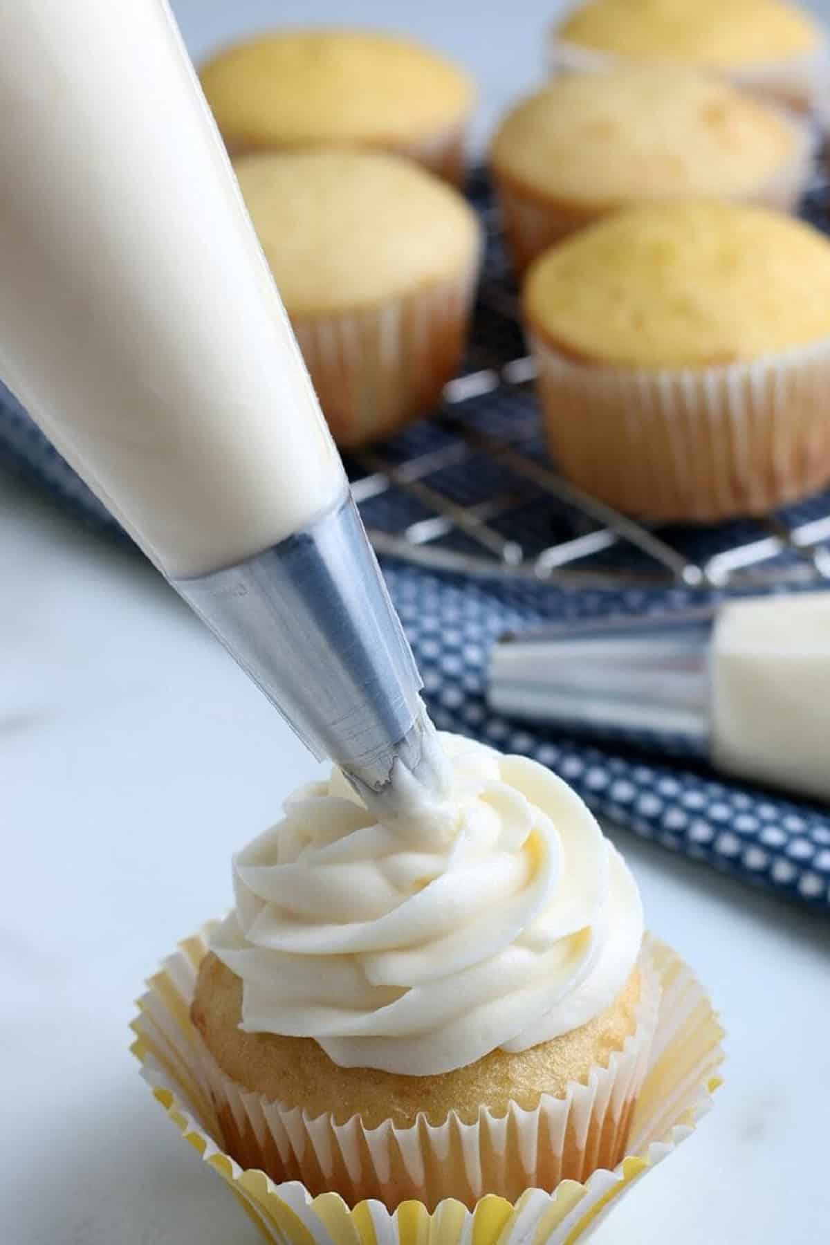 Thick and creamy with a delightfully tangy flavor, this Cream Cheese Frosting recipe requires just 4 basic ingredients and 15 minutes. Piping Cream Cheese Frosting on a Cupcake