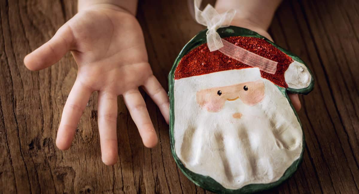 This 3-ingredient Salt Dough Recipe is perfect for handprint (or footprint) keepsakes and also making homemade ornaments. a hand printed santa ornament using a salt dough recipe