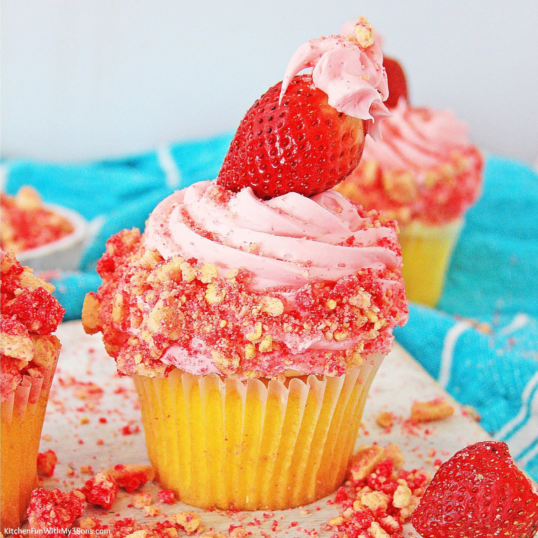 Strawberry crunch cupcake topped with a fresh strawberry