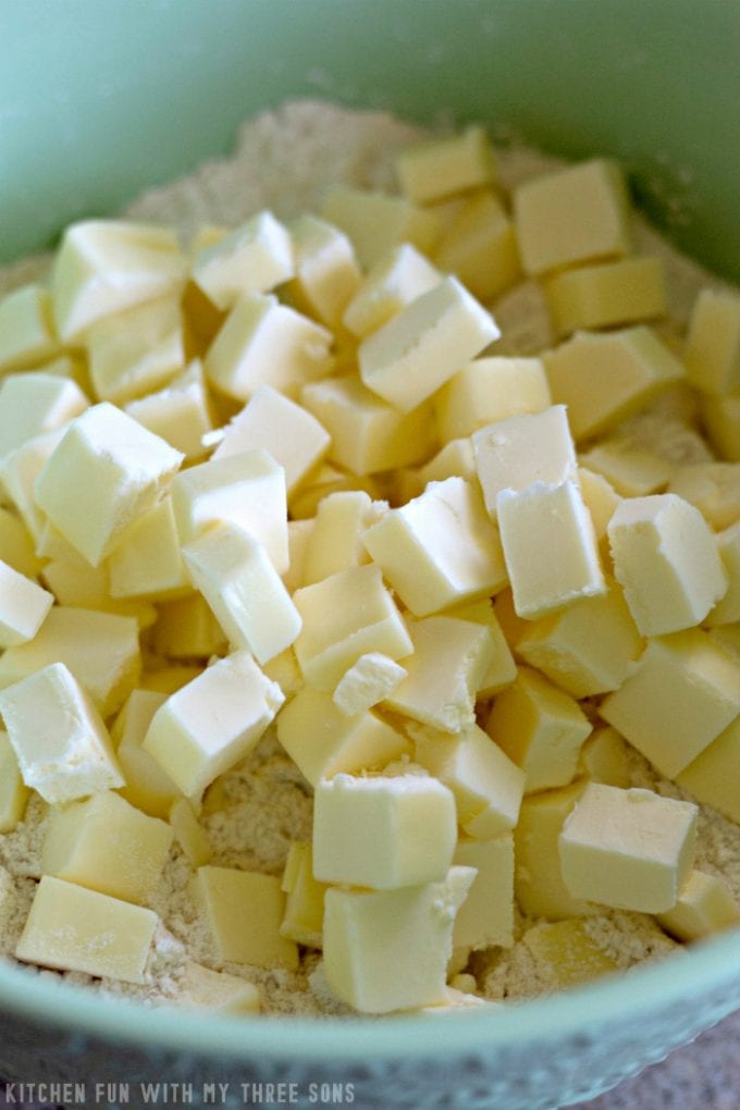 cubed butter in flour in a mint green bowl