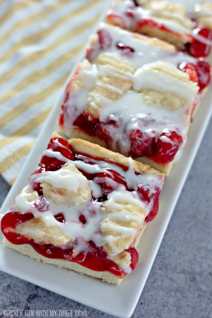 Easy Cherry Pie Bars on a white dish with a yellow and white striped napkin