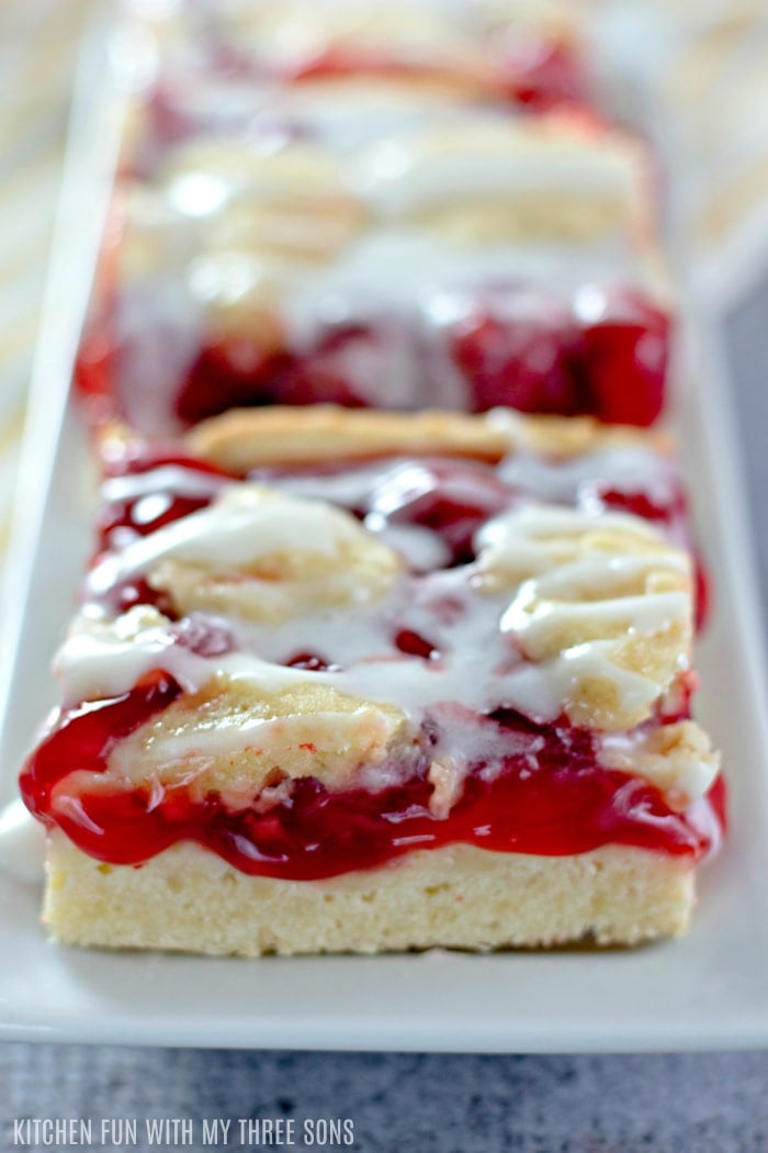 Three ooey-gooey Cherry Cookie Bars laid out on a plate.