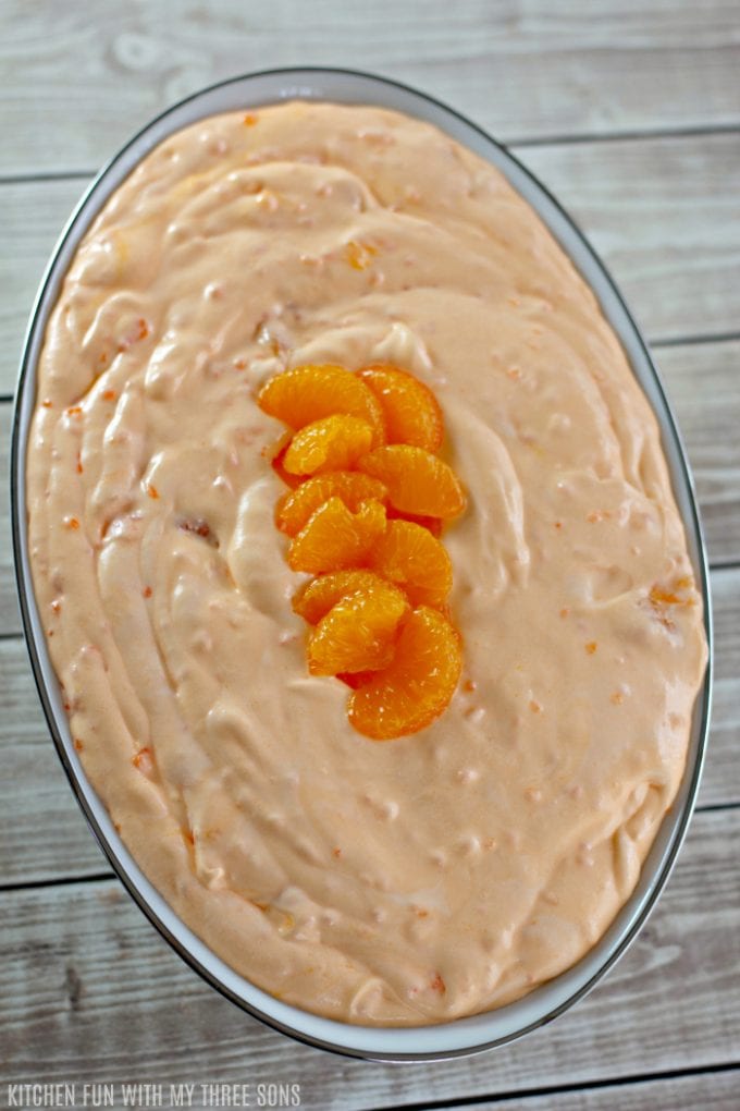 Easy Jello Creamsicle Salad in a white bowl with a silver rim with mandarin oranges on top