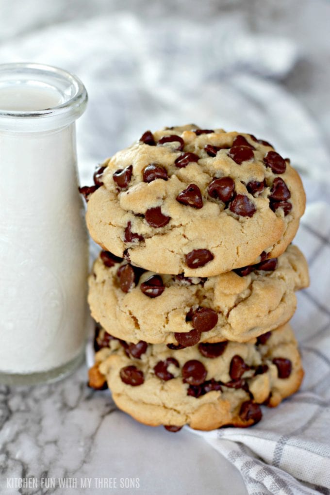 chocolate chip cookies stacked next to a glass of milk
