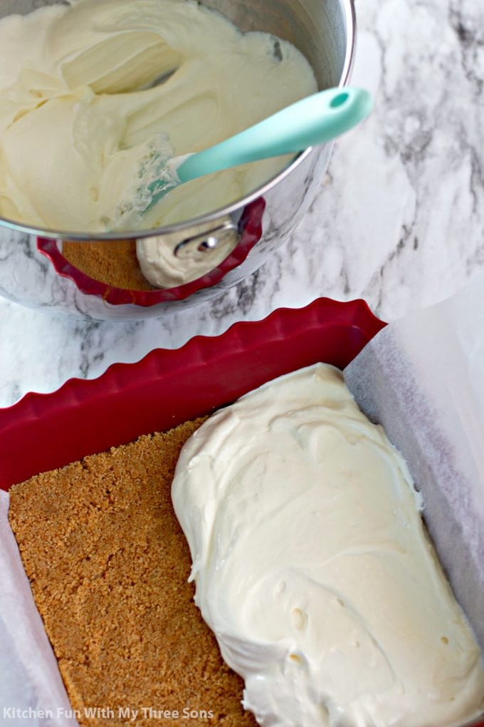 spreading whipped cheesecake over a graham cracker crust