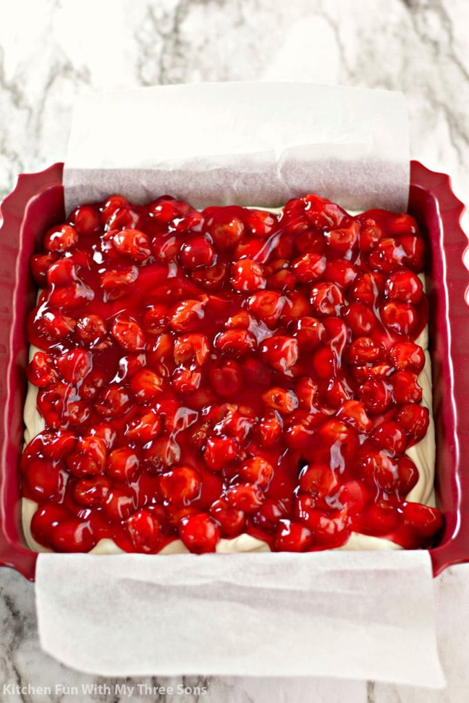 topping a no-bake cheesecake with cherries