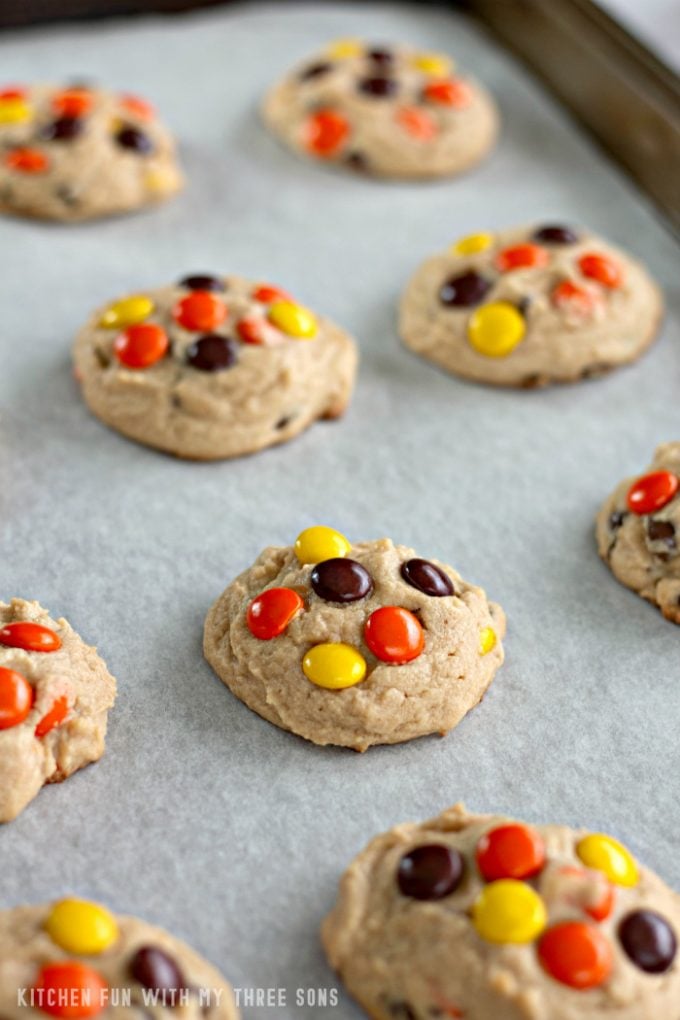 Reese's Pieces Peanut Butter Cookies on a parchment paper lined cookie sheet