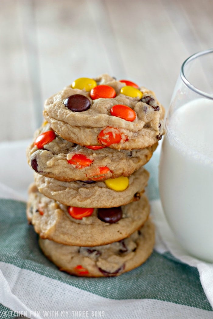 A stack of Reese's Peanut Butter Cookies next to a glass of milk.