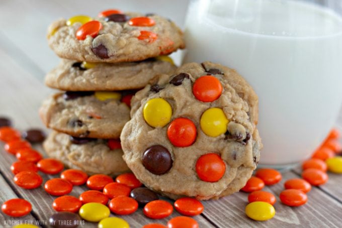 Reese's Pieces Peanut Butter Cookies stacked next to a glass of milk