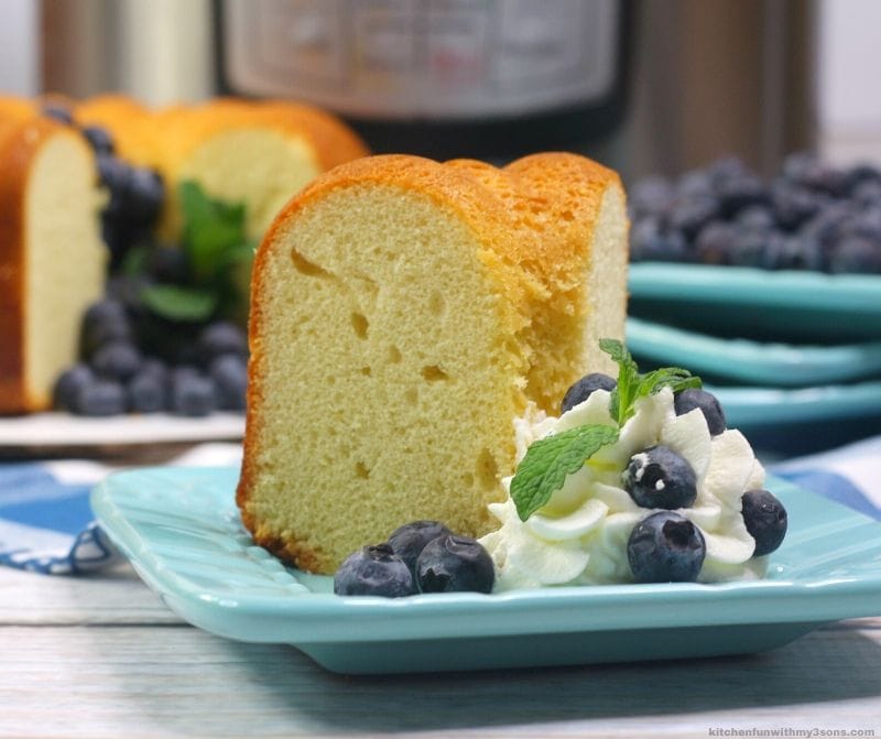 slice of instant pot pound cake on a blue plate with blueberries