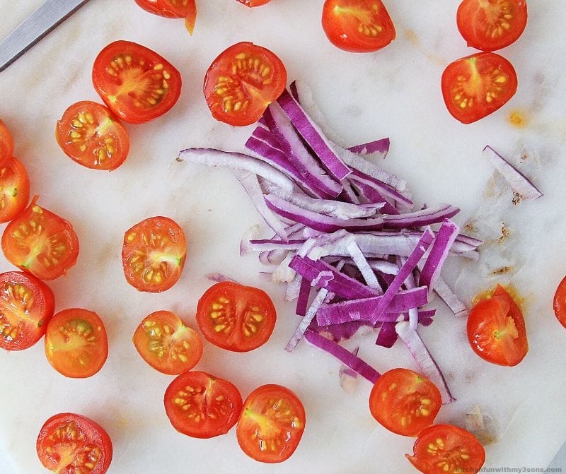 cut up tomatoes and red onion on a counter