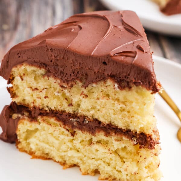 A slice of yellow cake on a white plate