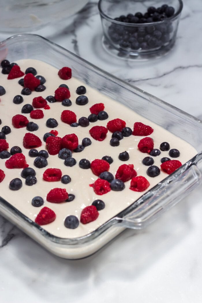 This American Flag Cake Recipe is easy to make and perfect for Memorial Day or 4th of July. fresh berries on top of cake batter