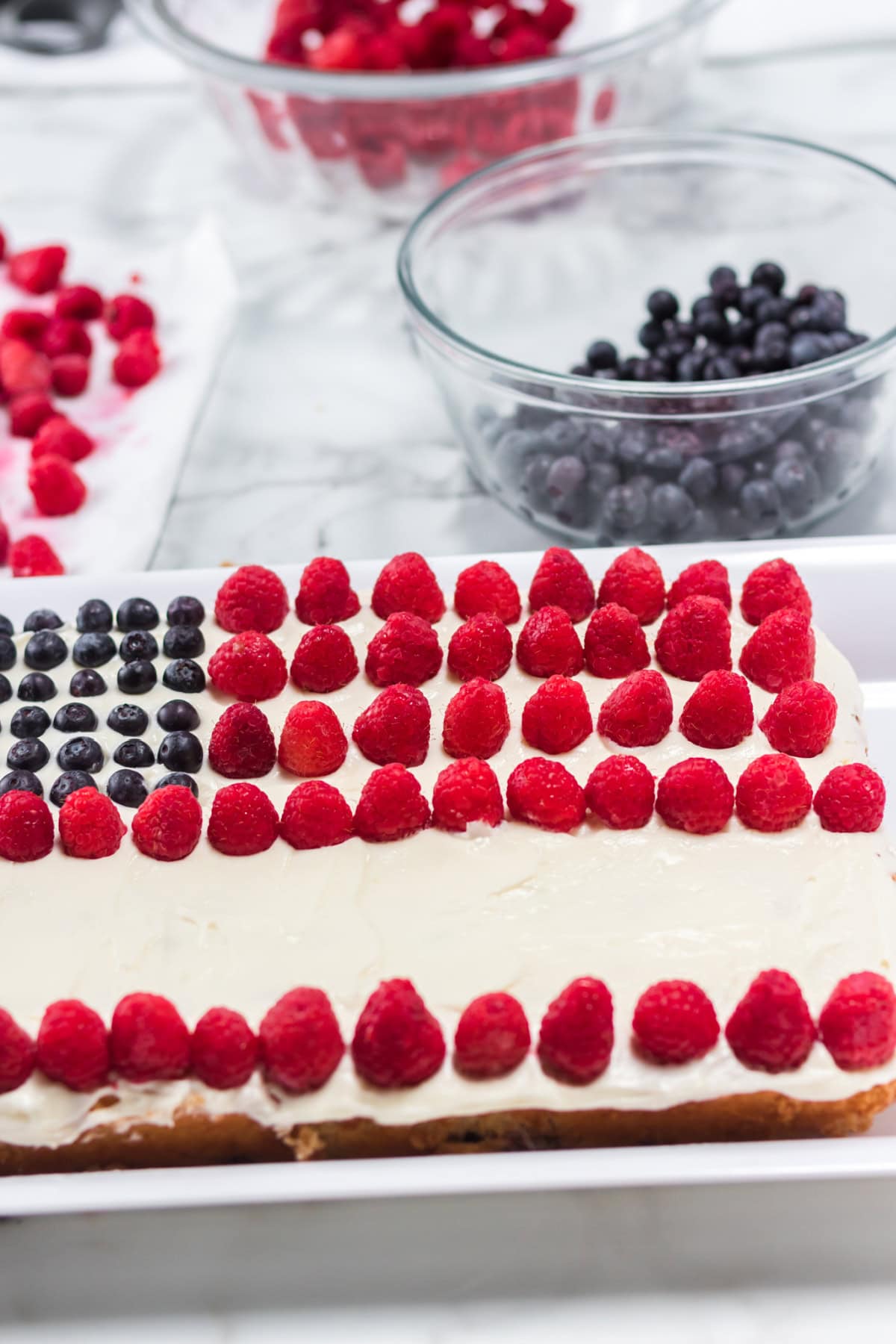 This American Flag Cake Recipe is easy to make and perfect for Memorial Day or 4th of July. decorating a cake with berries to look like a flag