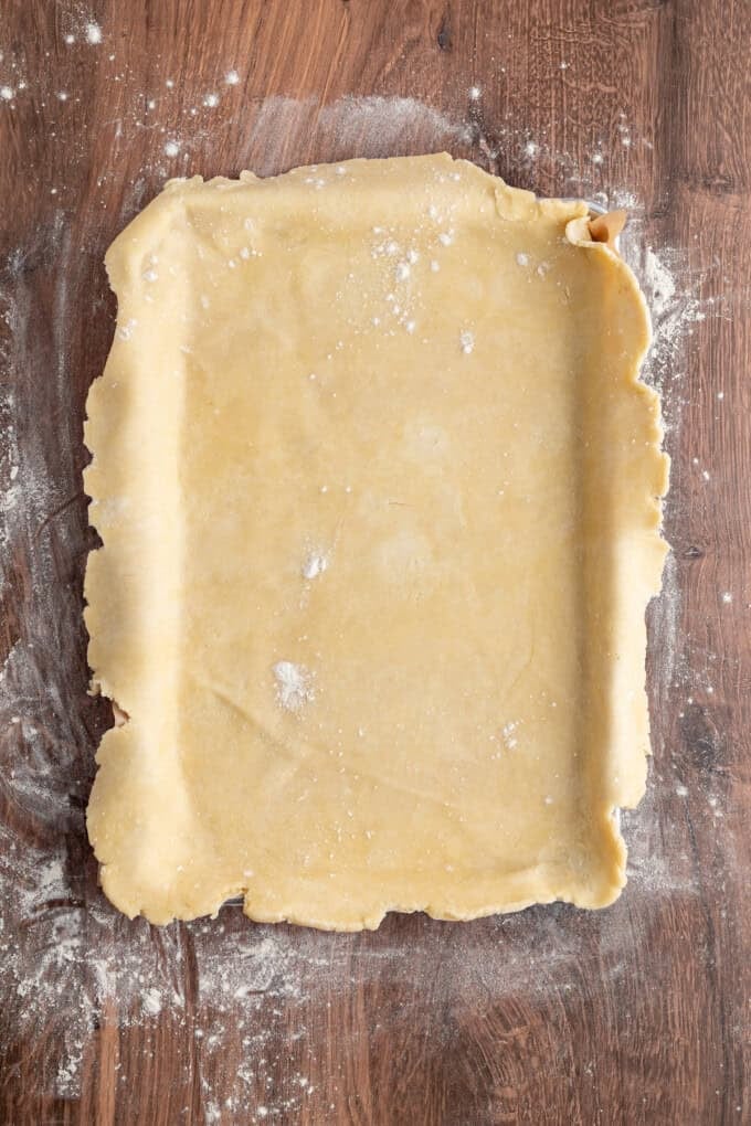 With a flaky, buttery crust and perfectly spiced apple filling baked in a jelly roll pan, Apple Slab Pie is ideal for holidays and gatherings. Pie crust laid out in a jelly roll pan