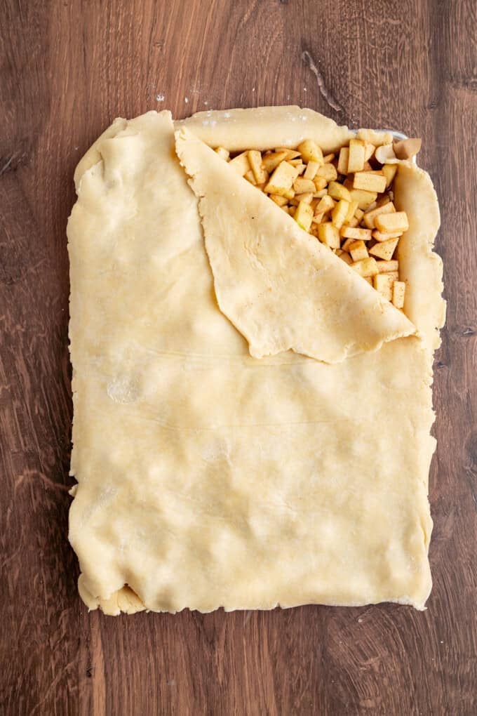 With a flaky, buttery crust and perfectly spiced apple filling baked in a jelly roll pan, Apple Slab Pie is ideal for holidays and gatherings. A rectangle of pie crust laid over apple pie filling