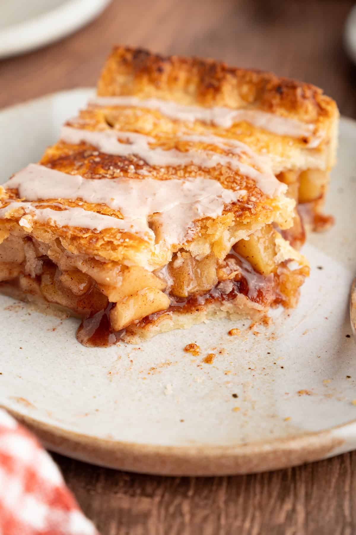 With a flaky, buttery crust and perfectly spiced apple filling baked in a jelly roll pan, Apple Slab Pie is ideal for holidays and gatherings. A slice of apple slab pie with a bite missing