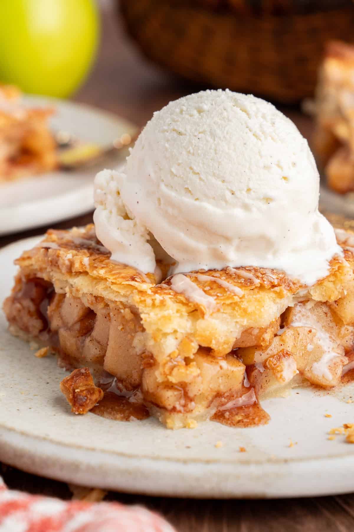 With a flaky, buttery crust and perfectly spiced apple filling baked in a jelly roll pan, Apple Slab Pie is ideal for holidays and gatherings. Apple Slab Pie slice on a plate with ice cream.