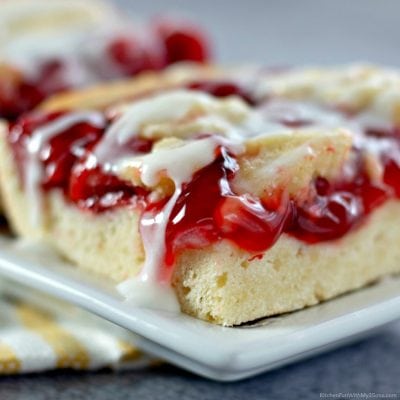 A close-up of a gooey pie bar with a fluffy sugar cookie base.