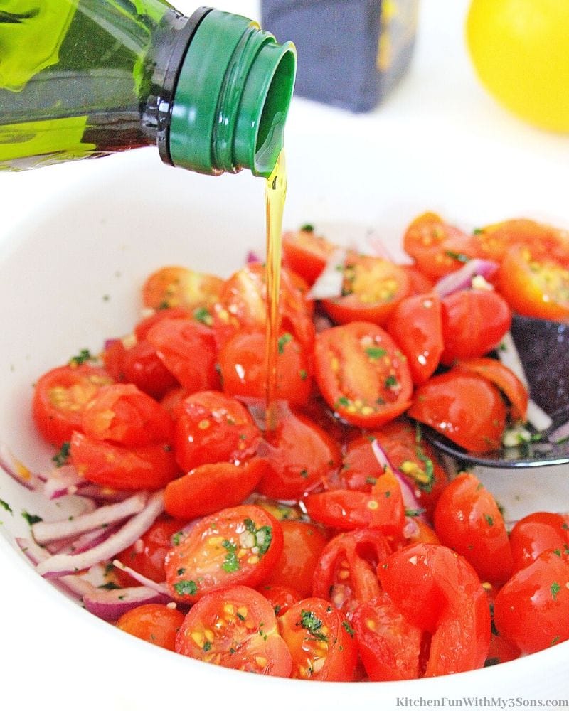 oil poured into tomatoes in a bowl