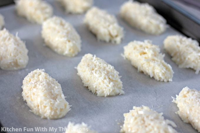 coconut bars on parchment paper on a cookie sheet