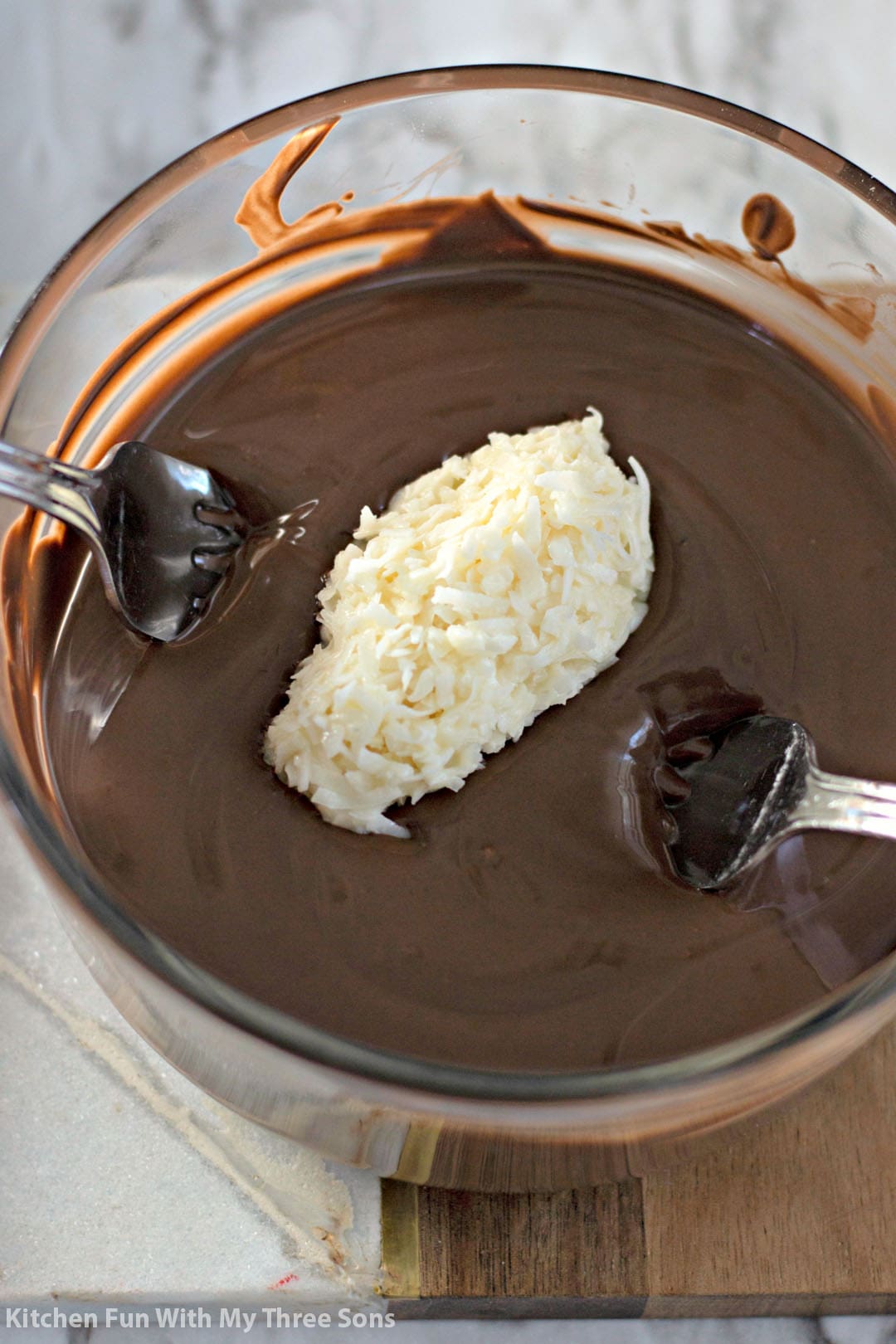 dipping coconut bars into melted dark chocolate