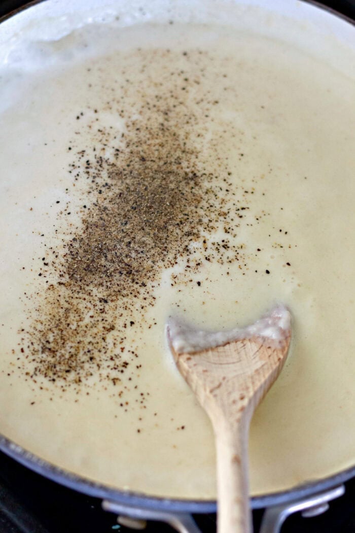 Stirring salt and pepper into gravy