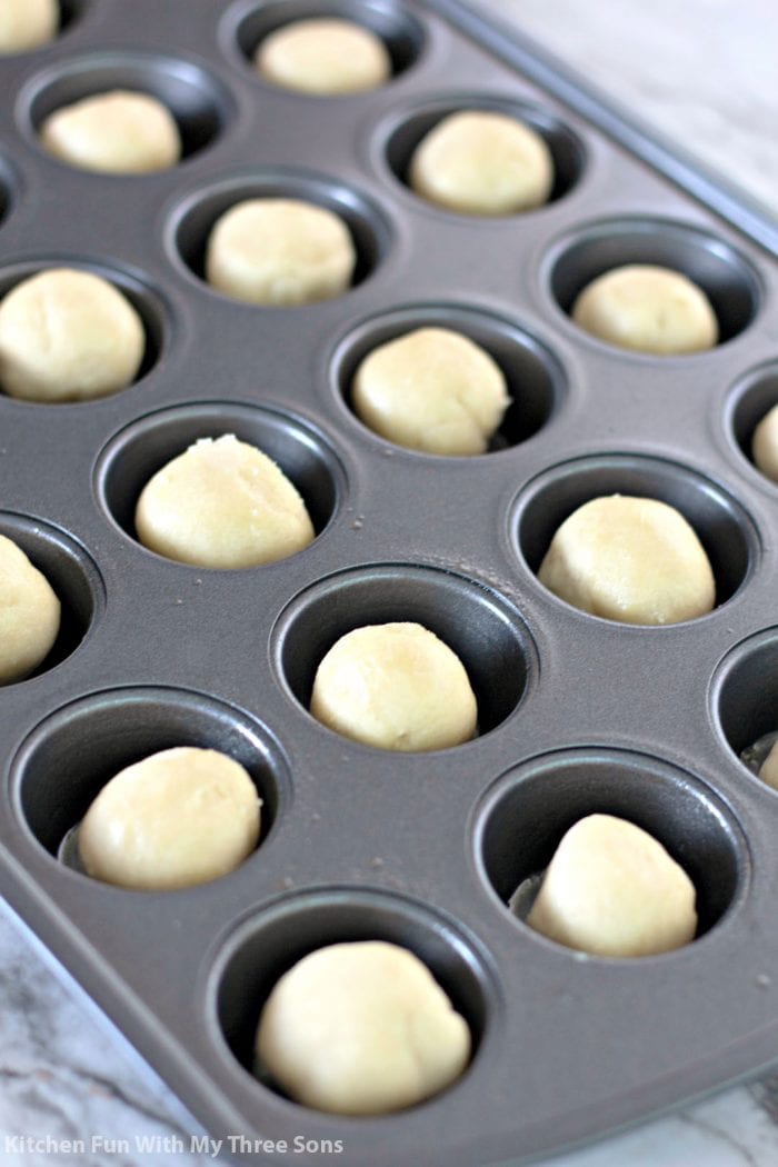 Balls of sugar cookie dough in a muffin tin