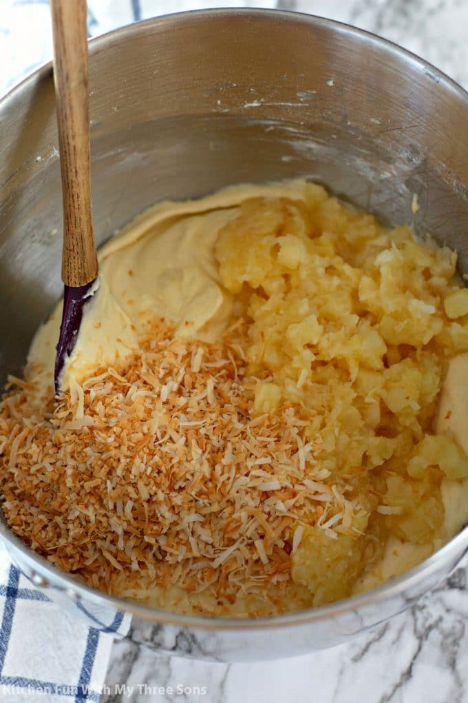 stirring toasted coconut and crushed pineapple into a cake batter