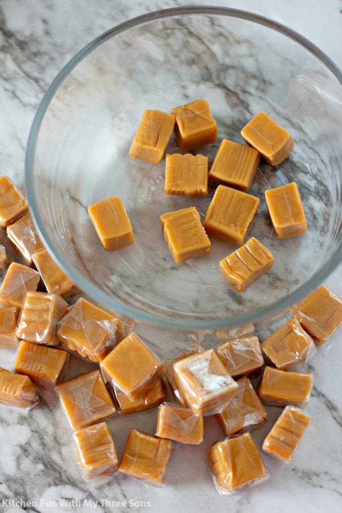 unwrapping caramels and pouring into a clear bowl