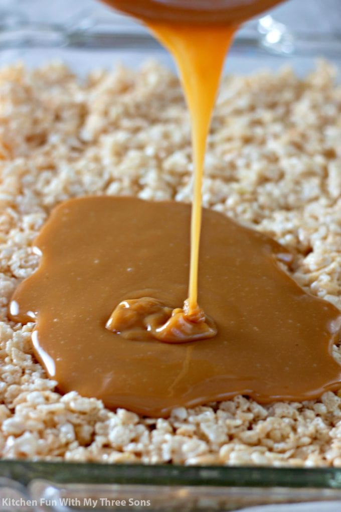 pouring melted caramel over rice krispies treats