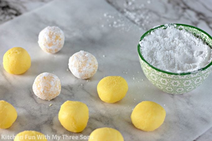 rolling lemon candies in powdered sugar