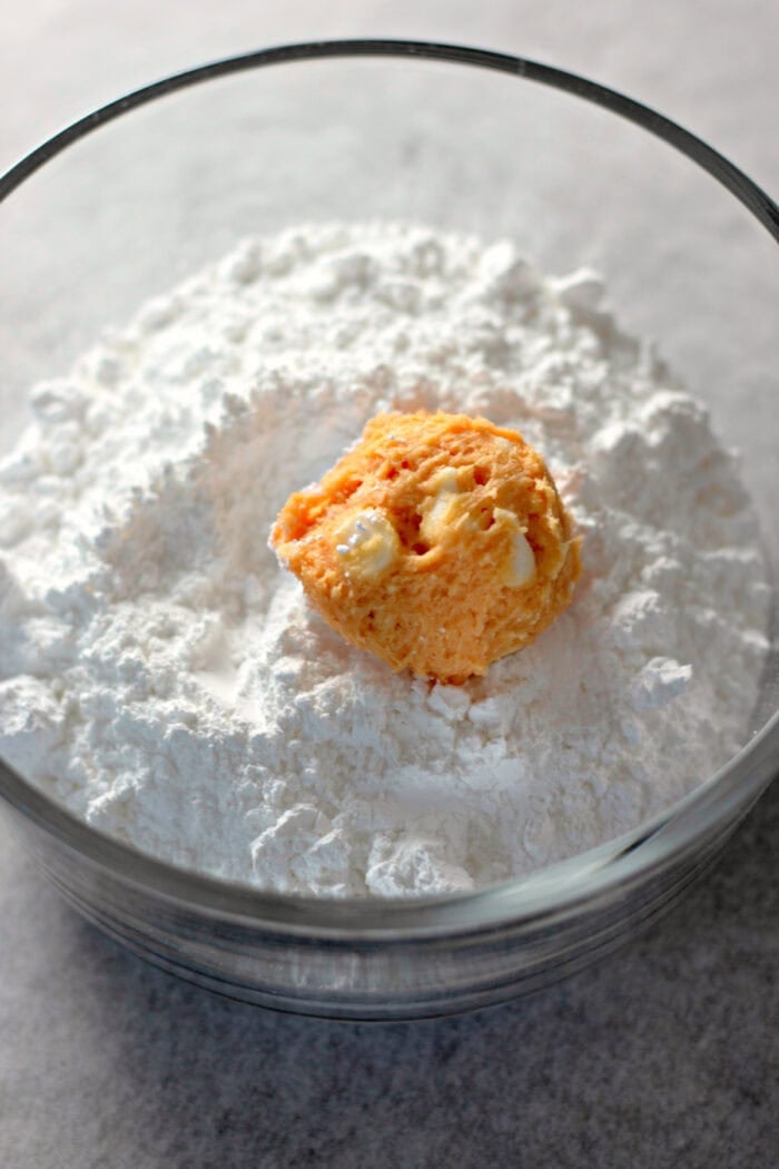rolling the dough ball into powdered sugar