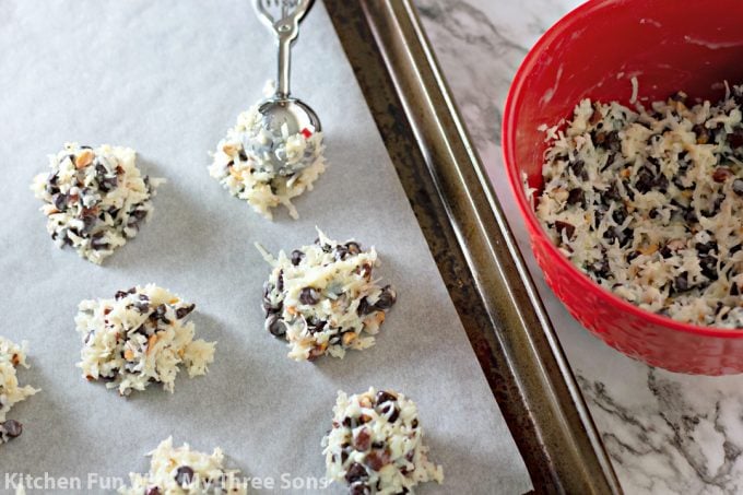 scooping cookies onto a parchment paper lined baking sheet with a cookie scoop