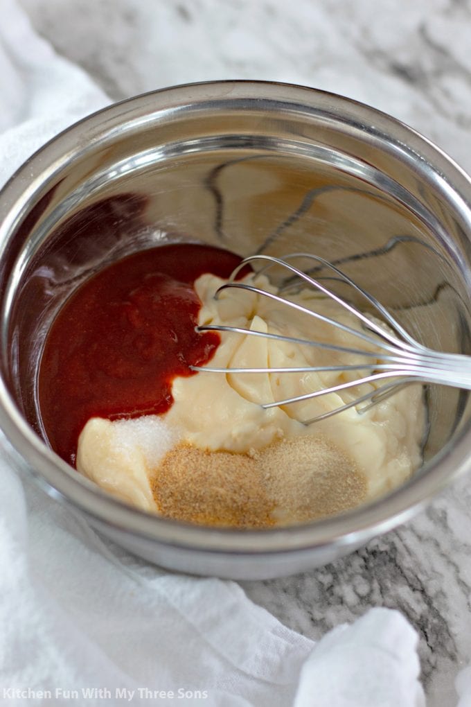 whisking together sriracha, mayonnaise, and seasonings in a metal bowl